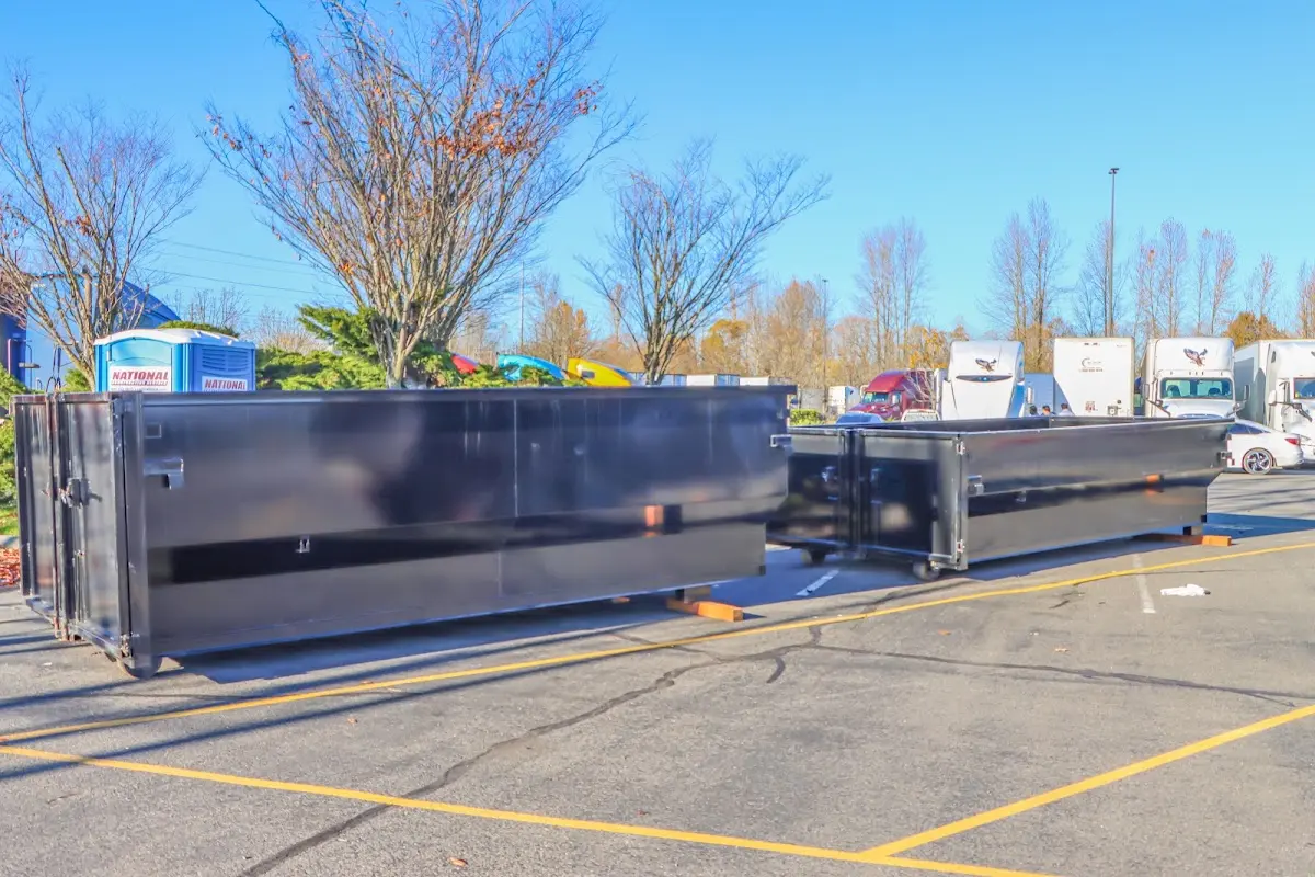 Professional dumpster rental service with roll-off container on residential driveway in Benner